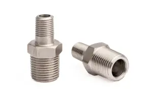 Dwa metalowe złączki hydrauliczne z gwintem 1 cal. Jedna stoi pionowo, druga leży.