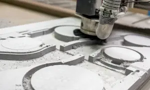 Frezowanie CNC tworzy precyzyjne kształty w materiale. Maszyna usuwa nadmiar, tworząc wgłębienia i kontury.