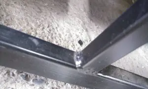 Solidne spawanie profili ocynkowanych, tworzące mocne połączenie konstrukcji metalowej na betonowym podłożu.