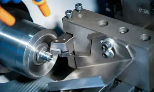 Precyzyjne toczenie aluminium na obrabiarce. Narzędzie skrawające nadaje kształt metalowemu elementowi.