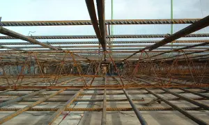 Siatka zbrojeniowa i stalowe pręty tworzą skomplikowaną konstrukcję, gotową do zalania betonem. To półfabrykat hutniczy, który wzmocni przyszły budynek.