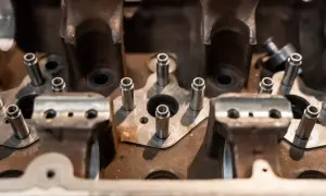 Metalowe kołki wystają z bloku silnika, przygotowane do wytaczania otworów.