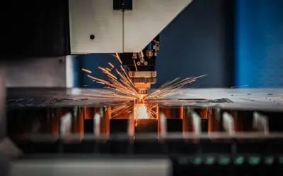 Precyzyjna obsługa maszyn CNC: laser tnie metal, sypiąc iskrami.