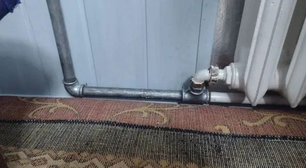 Instalacja grzewcza z metalowymi rurami, pokazująca, jak nagwintować rurę do podłączenia grzejnika.