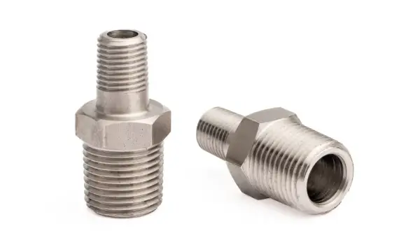 Dwa metalowe złączki hydrauliczne z gwintem 1 cal. Jedna stoi pionowo, druga leży.