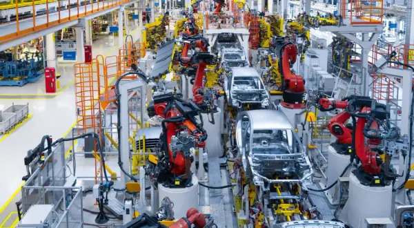 Linia produkcyjna Toyoty, gdzie roboty pracują nad montażem karoserii samochodowych, uosabiając filozofię kaizen.