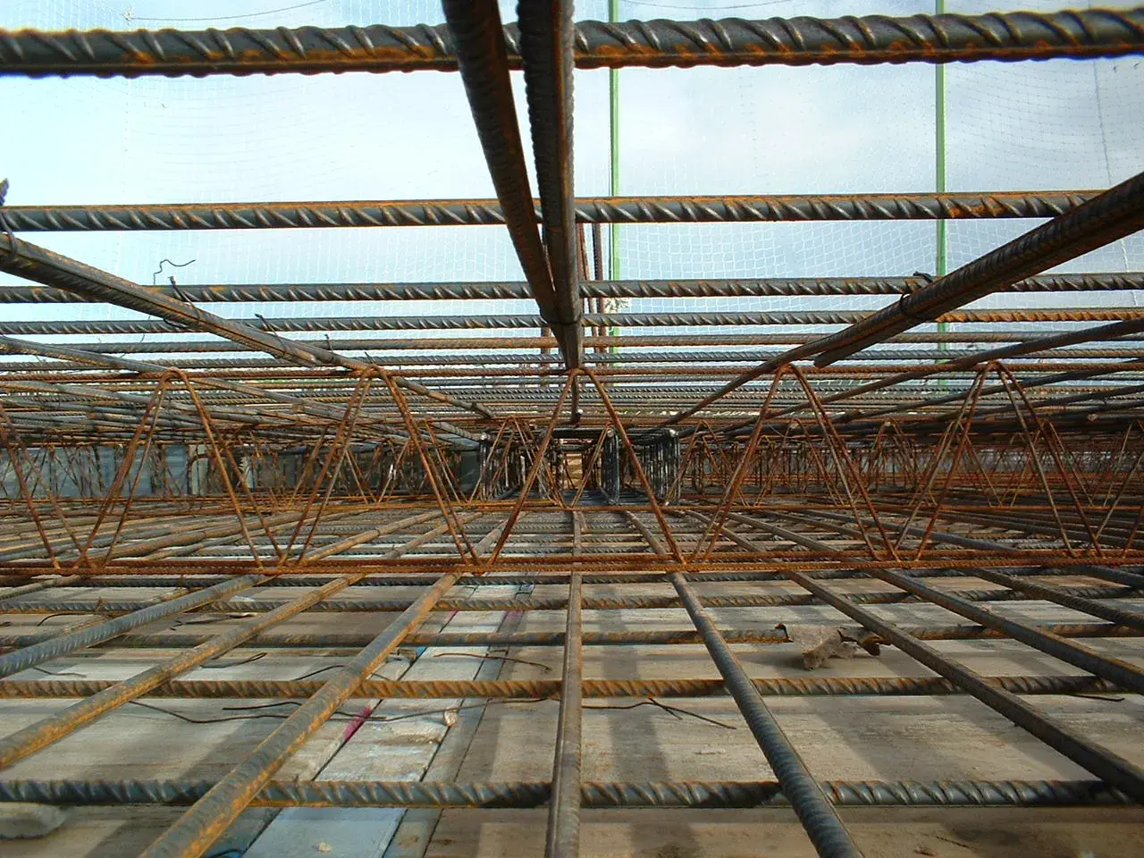 Siatka zbrojeniowa i stalowe pręty tworzą skomplikowaną konstrukcję, gotową do zalania betonem. To półfabrykat hutniczy, który wzmocni przyszły budynek.