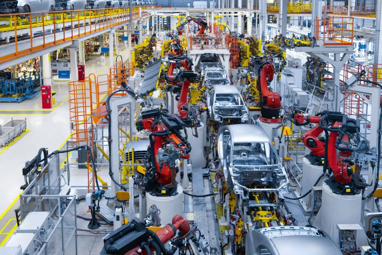 Linia produkcyjna Toyoty, gdzie roboty pracują nad montażem karoserii samochodowych, uosabiając filozofię kaizen.