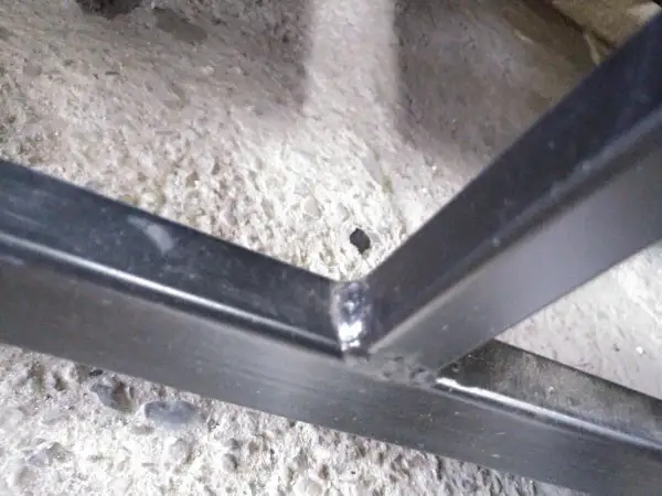 Solidne spawanie profili ocynkowanych, tworzące mocne połączenie konstrukcji metalowej na betonowym podłożu.